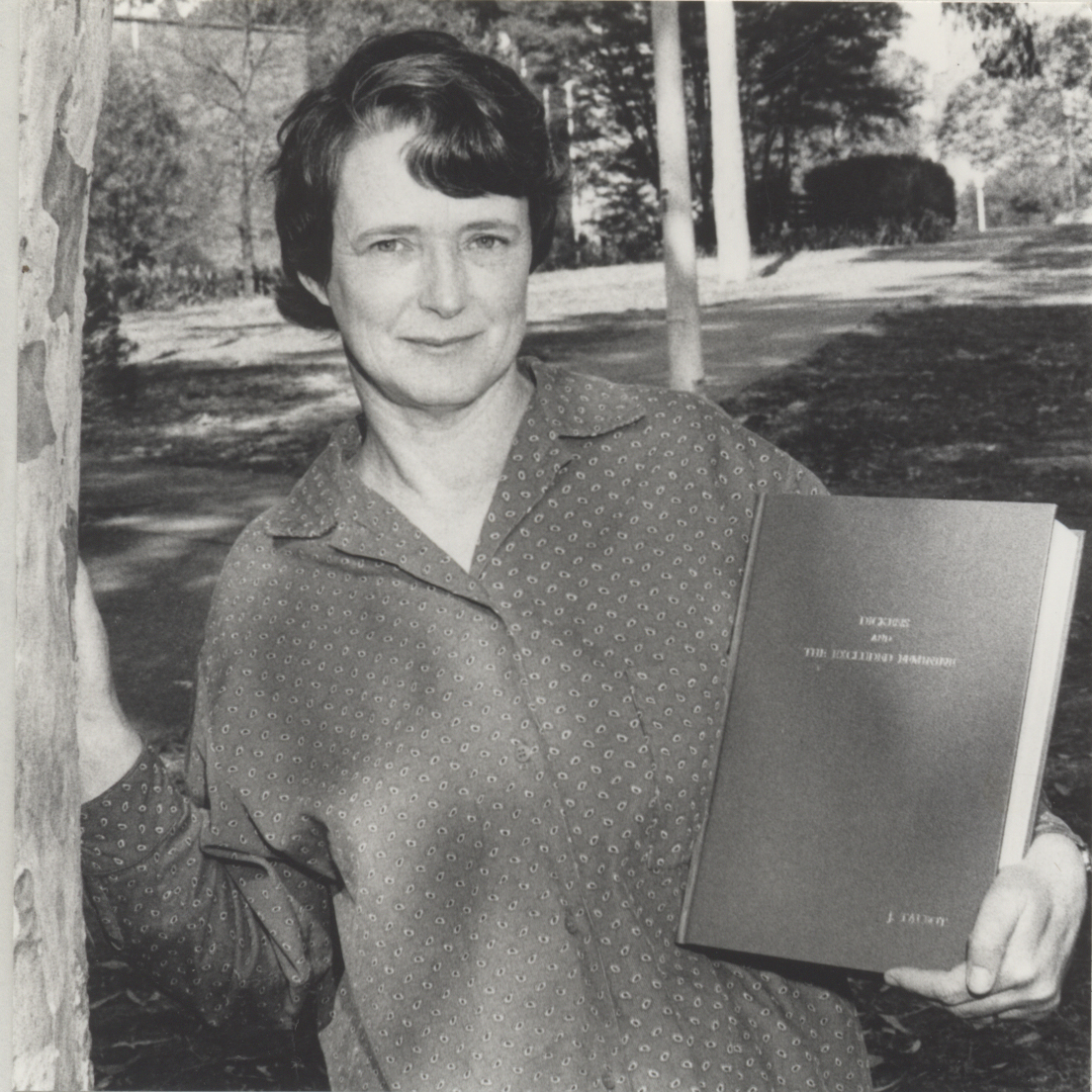 Dr Jean Talbot photographed in 1986 in the grounds of the University of Newcastle, holding a copy of her thesis 