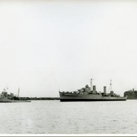 HMAS "Hobart" with Nobby's lighthouse and the breakwall in the background  - State Dockyard, Newcastle, NSW [n.d.]
