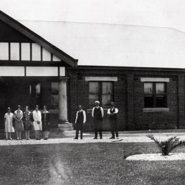 [Workers next to car, in front of] A Goninan Company Limited, Broadmeadow, NSW