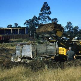 Loading soil for ramp filling storage bins, June 1956