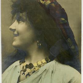 Postcard of a woman in a white cap with embroidered dress