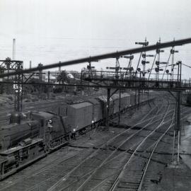 VR, D3 Class No. 647 4-6-0 Type hauling goods (with L Class electric locomotive passing in background) in Melbourne, [1960]