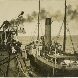 Loading men into a ship with wicker baskets