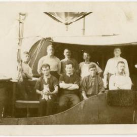 Photo of unidentified group of men on a ship, with cat