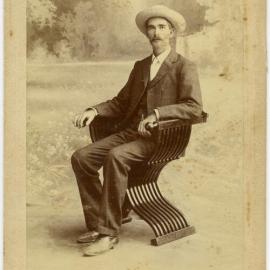 Unidentified man in elaborate folding chair.