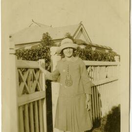 Photo of identified woman in dress near gate