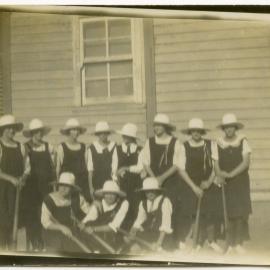 Photo of a group of unidentified schoolgirls in uniform with shovels.