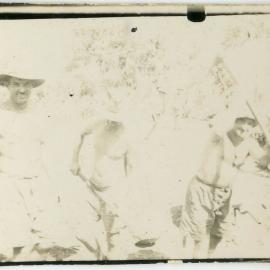Overexposed photo of three men working with pickaxes