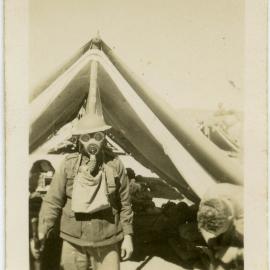 Photo of man in gas mask outside tent