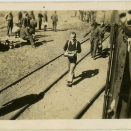 Photo of men carrying food and buckets along a railway