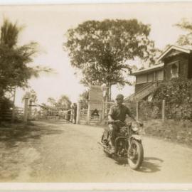 Unidentified motorcycle rider outside toll gate. Possibly Darwin