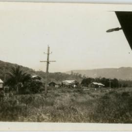 Grassy landscape with houses, possibly near Cairns