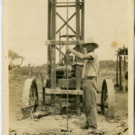 Man operating unknown machine, possibly a drilling or excavating machine.
