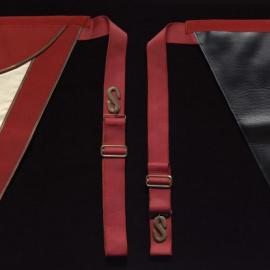 Triangle shaped apron with red, white and black with gold detail