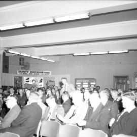 Man from audience speaking at mining safety convention, Safety Footware signage, NSW, 1959