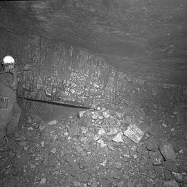 Miner inspecting coal seam wall, Mount Sugarloaf Colliery, West Wallsend, NSW, 1959