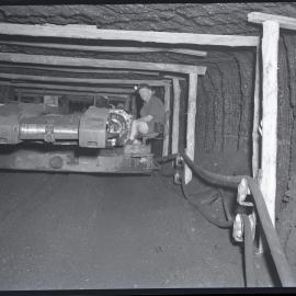 Miner sitting on machinery, Burwood [No 3] Colliery, Whitebridge, NSW,  1957