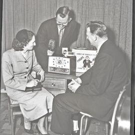 Woman being interviewed by two men at 2HD Radio promotion, Hamilton, NSW