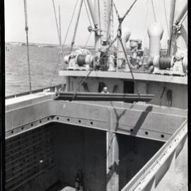 Loading steel on cargo ship, view below deck, 1964