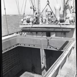 Loading steel on cargo ship, view of cargo hold, 1964