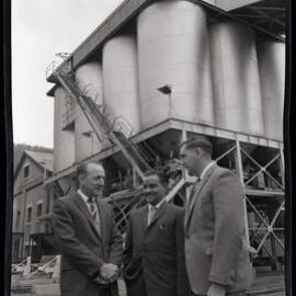 Picture of three men in suits with stairs in background, 1963