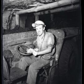 Coal worker driving underground vehicle, 1963