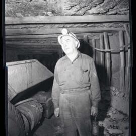 Coal worker underground holding lamp, 1963
