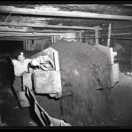 Man with headlight operating coal machinery, 1963
