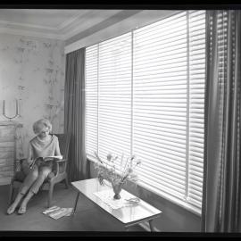 On location photo shoot with female model reading a magazine, 1964