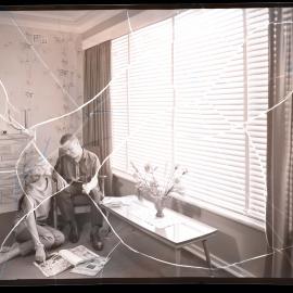On location photo shoot with couple in front of window with magazines, 1964