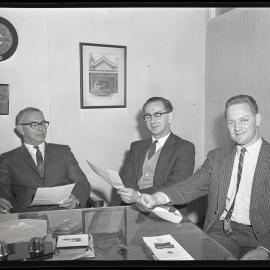 BMC Australia, three men at desks in jackets, 1963