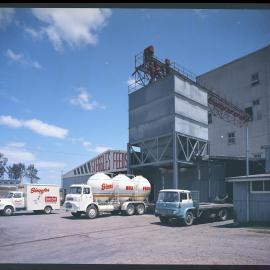 Steggles, feeds trucks outside building, 1965