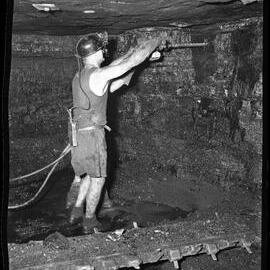 Miner drilling underground