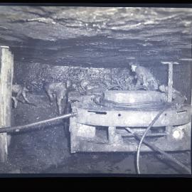 Men operating machinery underground