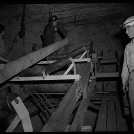 Bellambi Colliery, men underground moving piece of timber, 1961