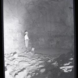 [Cave with water and man in hard hat], 1961