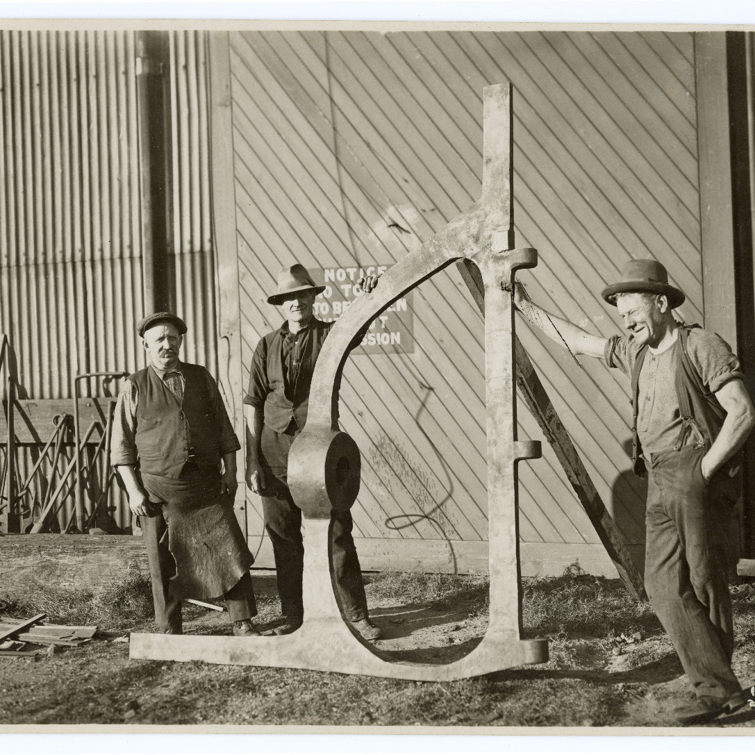 Three Men standing with Rudder Post at Walsh Island Dockyard, 1929