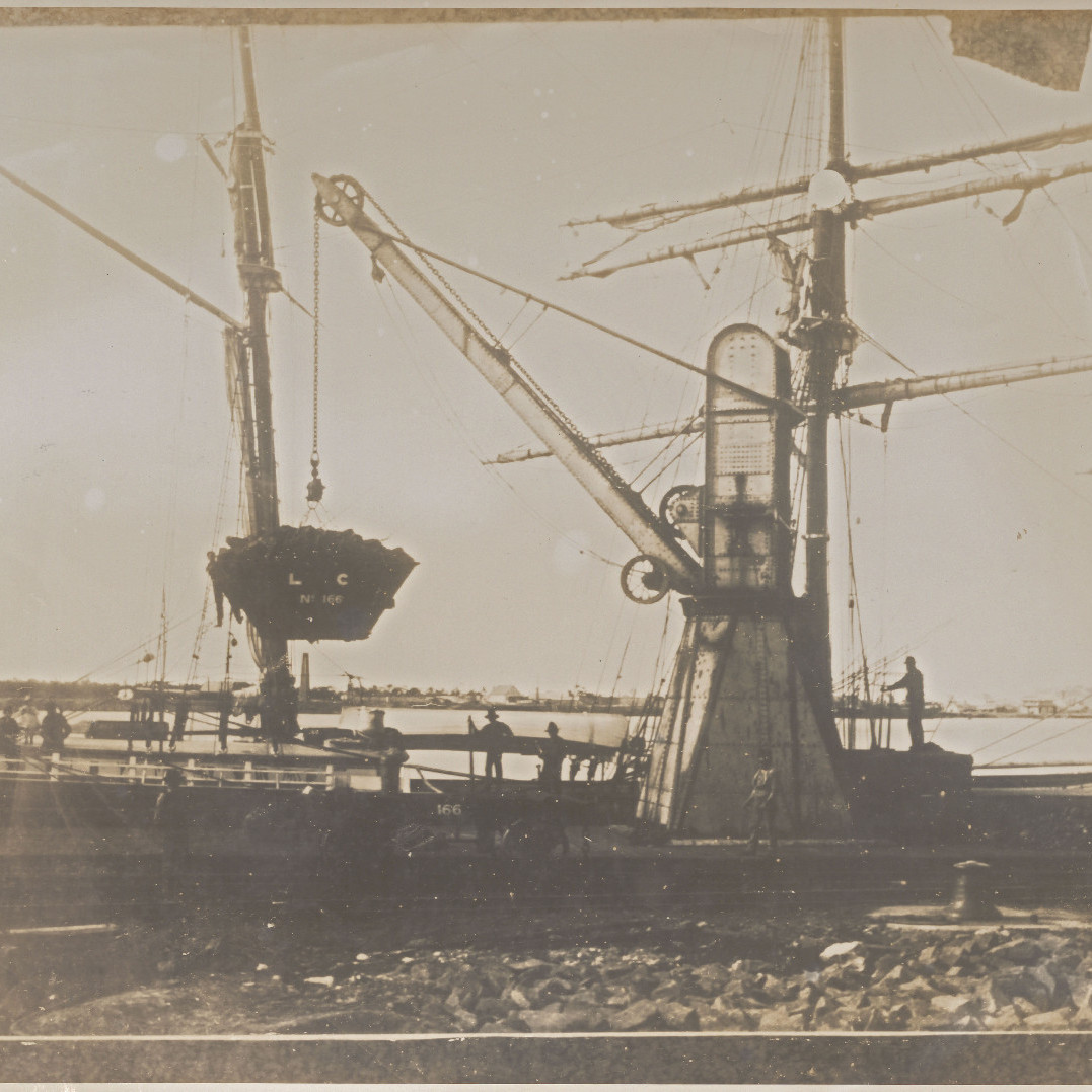 Crane Transporting Coal to a Ship