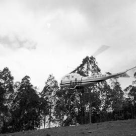 Helicopter carrying electric high tension wires on the Congewai range, for the Hunter Valley Council, May 20, 1965