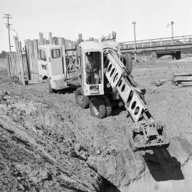 Worker operating an excavator, construction of new Belmore Bridge, NSW, 1961