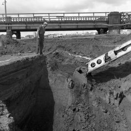 Brown's Enterprises worker watching digging for construction of new Belmore Bridge, Maitland, NSW, 1961