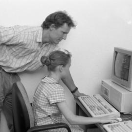 Rick Frost (Special Education) assists a child at a computer, the University of Newcastle, Australia - 1992