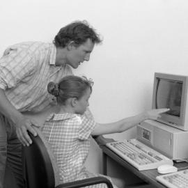 Rick Frost (Special Education) assists a child at a computer, the University of Newcastle, Australia - 1992