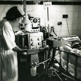A nurse checks monitoring equipment for a patient in the intensive care ward, Royal Newcastle Hospital, Newcastle, NSW, [late 1960s]