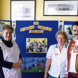 Mary Byrne on left, a "Pink Lady", with unidentified hospital staff in front of the display for Multicultural Health Week, Royal Newcastle Hospital, August 1999