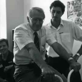 [Noel Carter, publicity officer, on bike, and unidentified men], Royal Newcastle Hospital, Newcastle, NSW