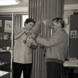 [Allan Smedley, left and Noel Carter, right] demonstrating how a piece of medical equipment works, Royal Newcastle Hospital, 1987