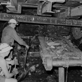 From left - Jack Blanche, Norm Stevens, George Drydon salvaging the continuous miner at Northern (Rhondda) Colliery, 23 February 1967, by Barry Howard