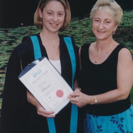 Nicole Williams with unidentified person holding her graduation certificate