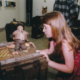 Child examining sculpture, Central Coast Campus art exhibition [n.d.].